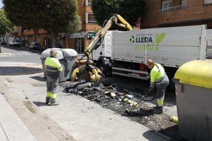 Operarios de Ilnet retirando ayer el contenedor calcinado. 