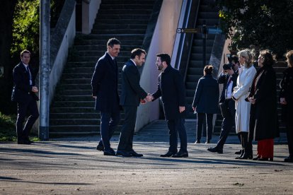 El presidente de la Generalitat, Pere Aragonès, encaja la mano con el presidente francés, Emmanuel Macron, en presencia del presidente español, Pedro Sánchez.