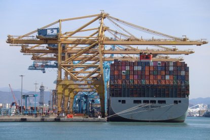 Un barco portacontenedores descargando mercancía en el puerto de Barcelona. 