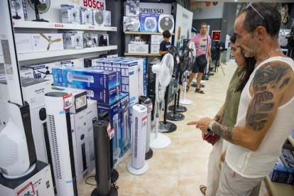 Una pareja mira algunos de los ventiladores expuestos en una tienda de electrodomésticos de Lleida.