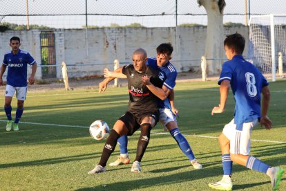 El atacante del Mollerussa Adri Fernández protege la posesión, con Toni Vicente intentando ganarle la posición para robar el balón. 