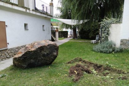 Una pedra de grans dimensions a tocar dels edificis que hi ha a pocs metres de la gasolinera de Rialp.