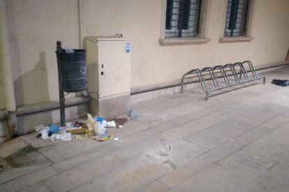 Una papelera en Tàrrega con basura por el suelo. 