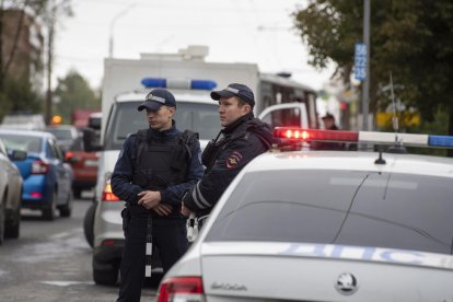 Dos agents de la policia russa vigilen els voltants de l’escola després del tiroteig.