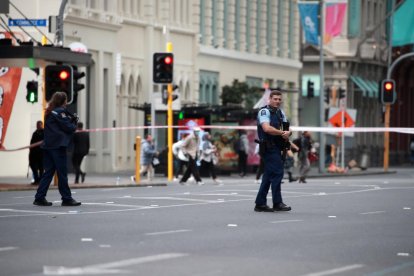 Policías hacen guardia en un área acordonada cerca del lugar de un tiroteo en Queen Street, Auckland, Nueva Zelanda.