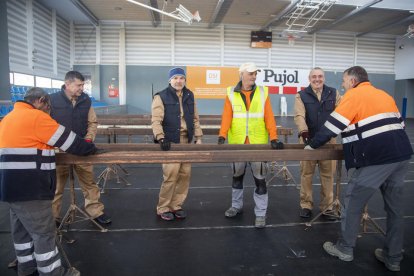 Amb vestuari marró, tres dels refugiats que treballen a la brigada de Tàrrega.