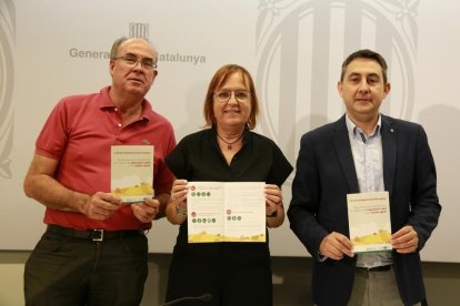 El director de los SS TT de Empresa y Trabajo, Vidal Vidal, la delegada del Gobierno, Montse Bergés, y el director general de Relaciones Laborales, Seguridad y Salud Laboral, Òscar Riu, con la nueva guía de prevención de riesgos al sector agrario