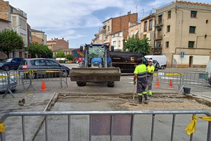 La brigada treballant per eliminar el sorral de la plaça.