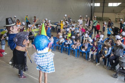 Baile de ‘capgrossos’ con los participantes levantando la gorra en el pabellón. 