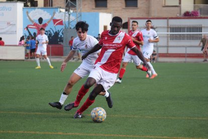 Un jugador de l’Artesa de Segre controla la pilota davant de la pressió d’un del Balaguer.