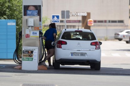 Imatge d’arxiu d’una dona proveint-se de combustible en una estació de servei.