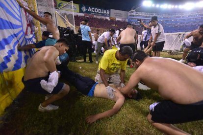 Aficionados y servicios médicos atienden a una persona en el estadio.