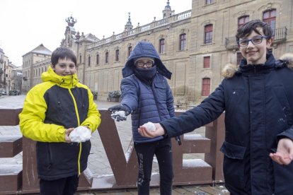 Tres nens jugant ahir a primera hora de la tarda amb la neu que va caure a Cervera.