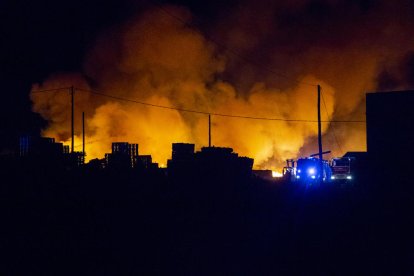 Les flames van arrasar piles de palets i els Bombers van treballar ahir a la nit per evitar que afectés una nau industrial.