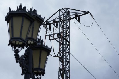 Imagen de una farola junto a una torre eléctricca.