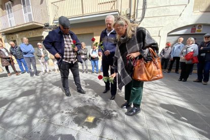 Familiares de una persona deportada en los campos de concentración nazi, depositando una rosa encima de un adoquín 'Stolpersteine' instalado recientemente en la Seu d'Urgell.