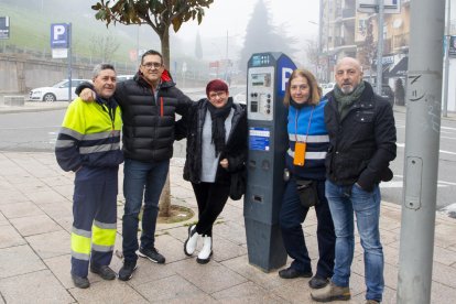 Varios empleados del servicio que ahora pasa a manos de la Paeria, junto a un parquímetro.