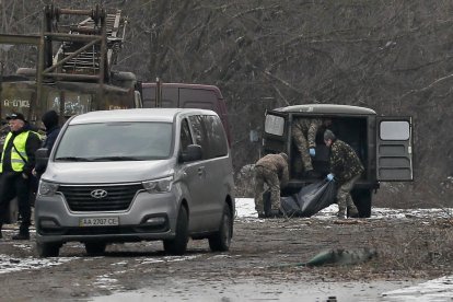 Efectivos militares trasladan el cuerpo de un hombre muerto cuando un misil ruso impactó en Kyiv.