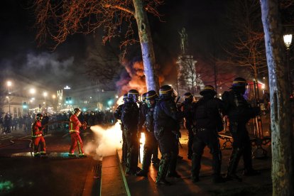 Bomberos apagan un fuego durante las protestas en París el martes por la noche.