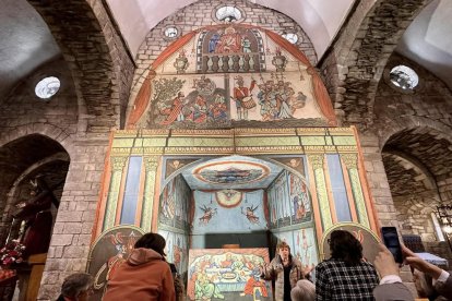 Turistes mirant les pintures col·locades a l’altar major de l’església de la Purificació.