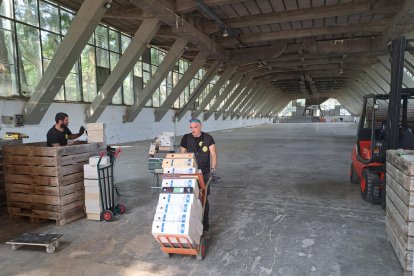 Operarios cargando y recogiendo material de oficina de la Fira en el Palau de Vidre, ayer por la mañana.