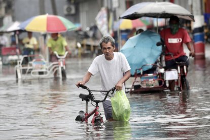  Un hombre vadea por una carretera inundada en Valenzuela.