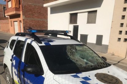 La luna delantera del coche patrulla quedó destrozada.