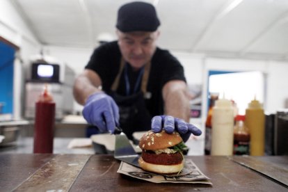 Un cocinero presenta una hamburguesa elaborada con proteína vegetal. 