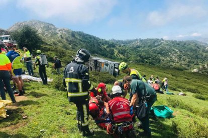 Efectivos del SEPA atienden a una de las heridas en el vuelco de un autobús en la subida a los Lagos de Covadonga.