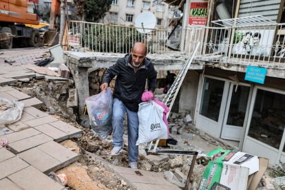 Un home treu unes quantes pertinences de casa, afectada pels terratrèmols.