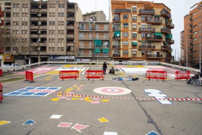 Vista general del mural que están pintando en el pavimento de la plaza del Clot de les Granotes.