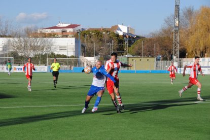 Adrià Fernández, autor de un gol, pugna con un jugador rival por el control del balón.