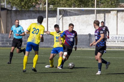 El capità del Tàrrega protegeix la possessió davant la pressió rival.