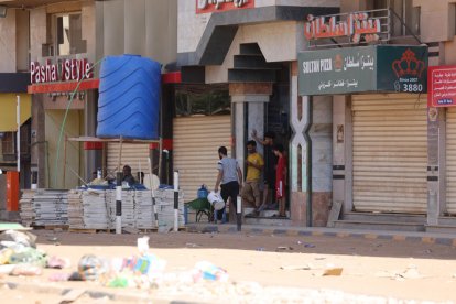 Una persona transportant objectes en un carretó pels carrers del Sudan.