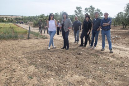 La consellera Teresa Jordà, al centre, en la visita a camps arrasats pels conills a Verdú.