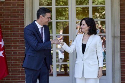 Sánchez y Ayuso sonríen en su saludo ante las cámaras.