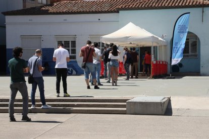 Diverses persones fent cua ahir a la tarda al punt de vacunació contra la Covid a Alcarràs.