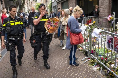 Una policia es disposa a deixar flors on va ser tirotejat De Vries.