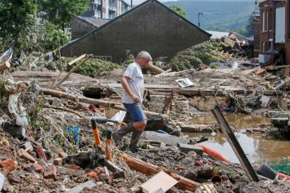 Un home camina entre les restes d’edificis destrossats per les riuades a la ciutat belga de Pepinster.