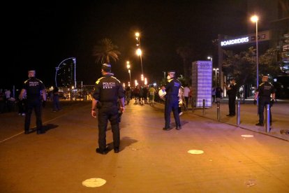 Policías desalojando a personas en la playa de Barcelona. 