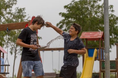 Guerra d’aigua entre dos nens de Lleida per fer front ahir a la calor.