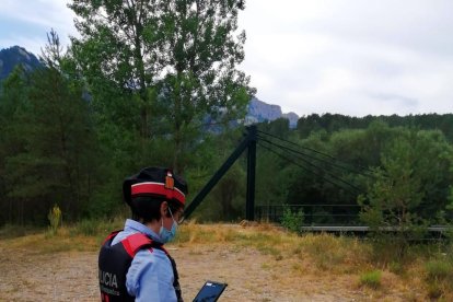 Un agent dels Mossos d’Esquadra al costat de la foguera.