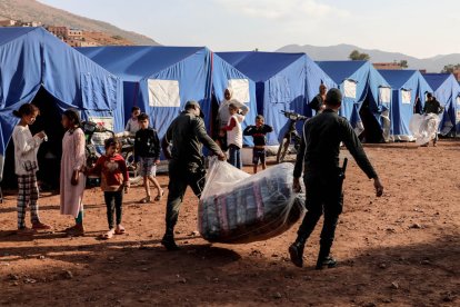 Soldats transporten articles de socors en un campament per als afectats pel terratrèmol.