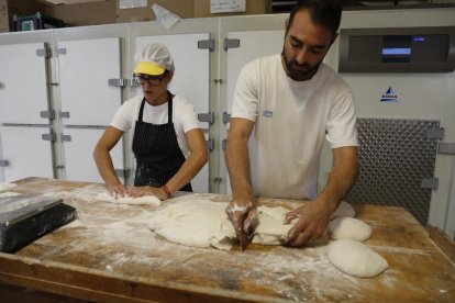 Jordi Martí Llaràs, del Antic Forn i Pastisseria J.Martí del Secà de Sant Pere, trabajando la masa junto a una empleada.