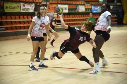 La jugadora del Lleida Handbol Cati Casasola llança la pilota després d’anar-se’n de dos rivals.