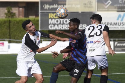 Un jugador del Tàrrega intenta controlar el balón entre dos futbolistas del Borges.