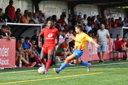 Un jugador de l’Alpicat prova d’avançar davant de la pressió d’un jugador rival.