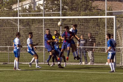 Un jugador del Guissona pugna amb un rival per mirar de desviar la pilota. 