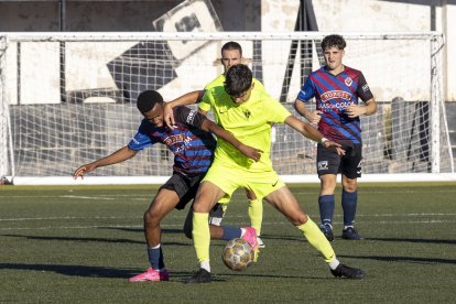 Un jugador del Tàrrega pugna amb un adversari pel control de la pilota durant una situació del partit.