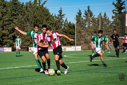 Un jugador del Castellar intenta evitar un company amb la pilota.